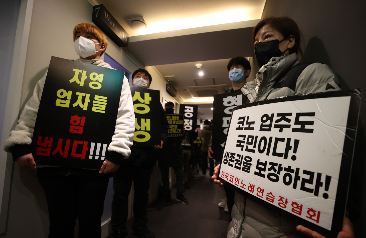 9일 자정 서울 서대문구의 한 코인노래방에서 코로나19 대응 전국자영업자 비상대책위 주최로 열린 방역기준 불복 개점 시위에서 참석자들이 정상 영업을 촉구하며 구호를 외치고 있다. 이날 시위에서 코인노래방 업주들은 방역 당국의 획일적인 영업시간 제한 폐지, 형평성 있는 방역기준 조정과 대책 마련을 촉구했다. [연합]