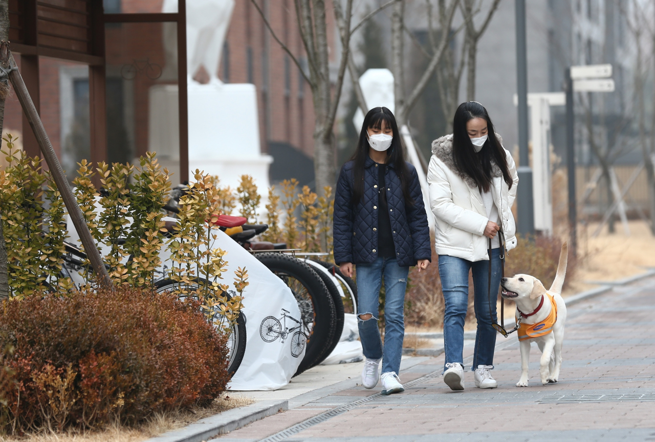 지난 1일 인천 중구 중산동에서 퍼피워커 유수영(43) 씨와 예비 안내견 푸름이를 만났다. 유 씨가 딸과 함께 푸름이를 산책시키는 모습. [삼성화재 안내견학교 제공]