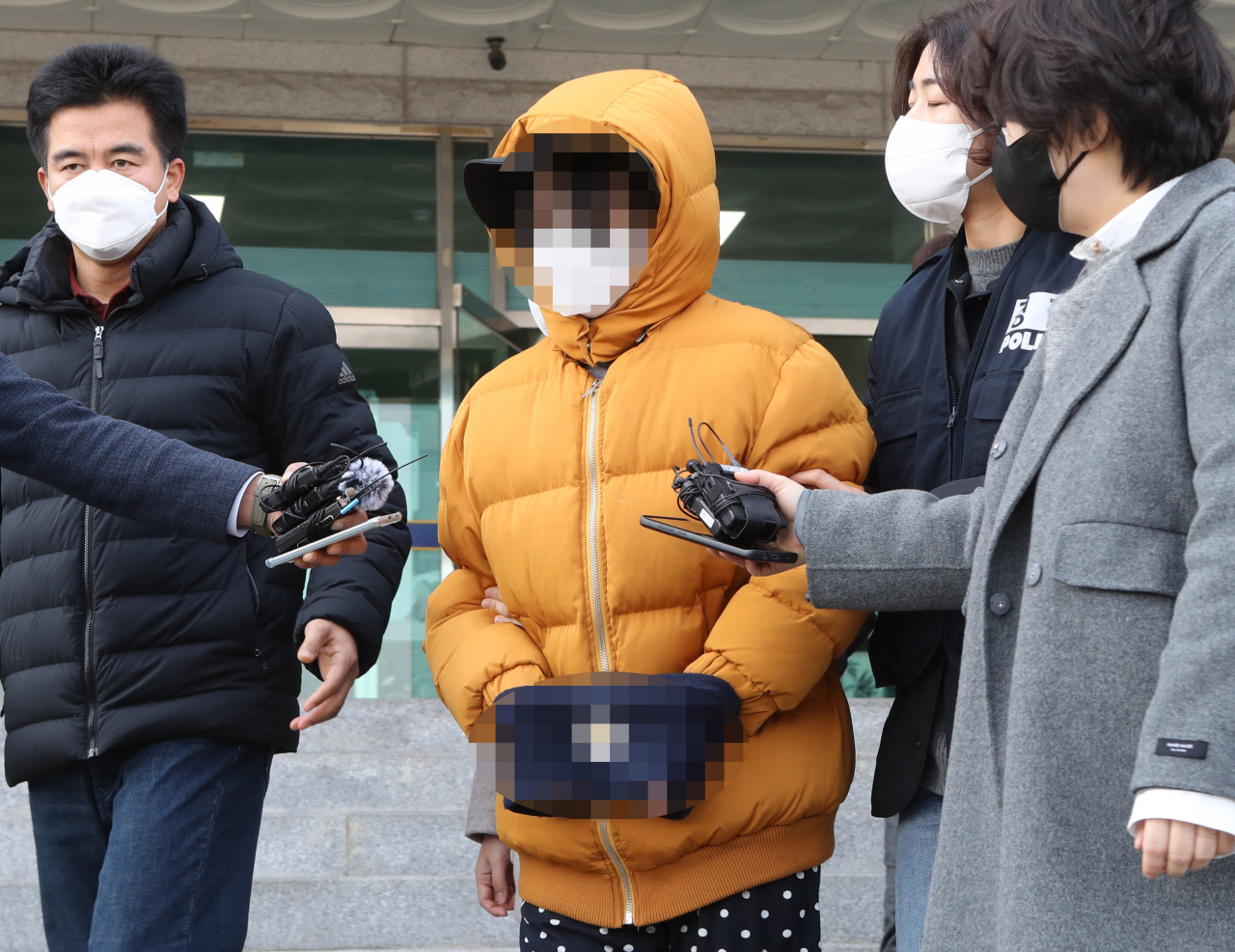 12일 오전 전북 전주시 덕진구 덕진경찰서에서 생후 2주된 아들을 때려 숨지게 한 부모가 말 없이 호송차로 이동하고 있다. [연합]