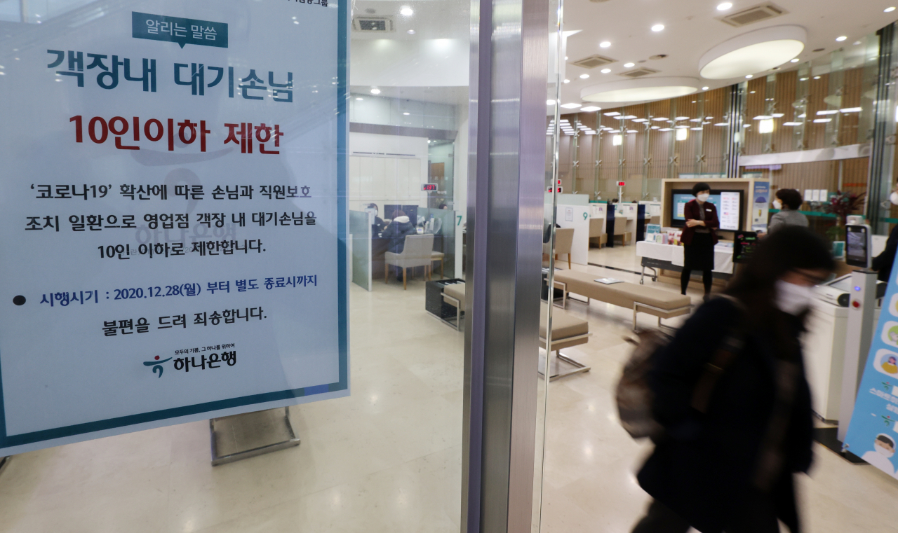 서울 명동 하나은행 본점 객장 앞에 10인 제한 관련 안내문이 부착되어 있다. [연합]