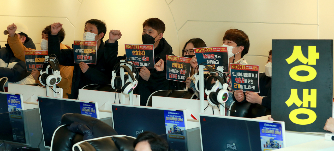 지난 8일 자정 서울 강서구의 한 PC방에서 코로나19 대응 전국자영업자 비상대책위원회 주최로 열린 방역기준 불복 개점 시위에서 참석자들이 정상 영업을 촉구하며 구호를 외치고 있다. [연합]