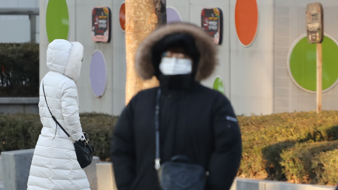 반짝 추위가 찾아온 지난 8일 오전 서울 시내에서 시민들이 모자가 달린 두툼한 외투를 입고 지나가고 있다. [연합]