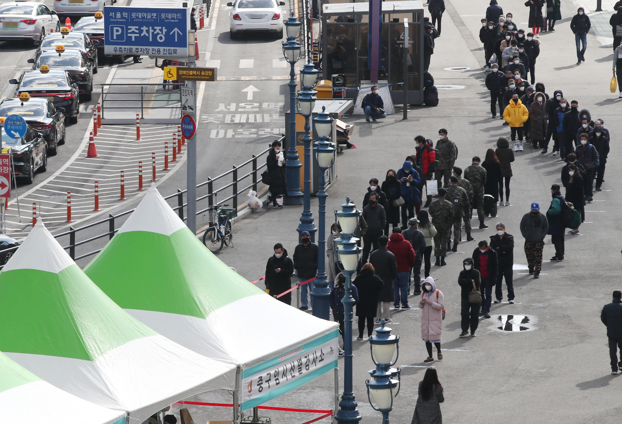 15일 오후 서울역에 마련된 코로나19 임시 선별검사소를 찾은 시민들이 길게 줄을 서 있다. [연합]