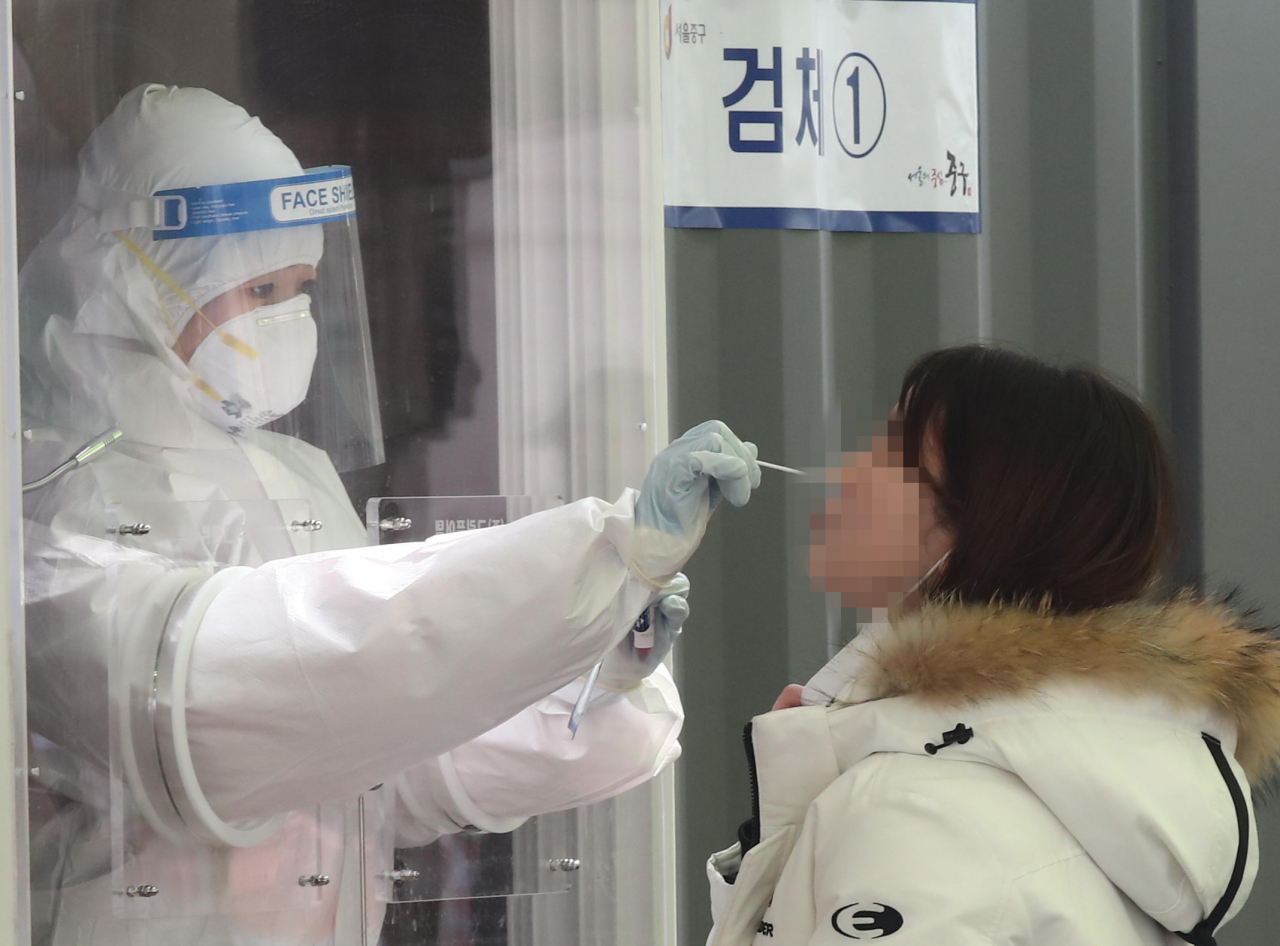 15일 오후 서울역에 마련된 코로나19 임시 선별검사소에서 의료진이 검체를 채취하고 있다. [연합뉴스]
