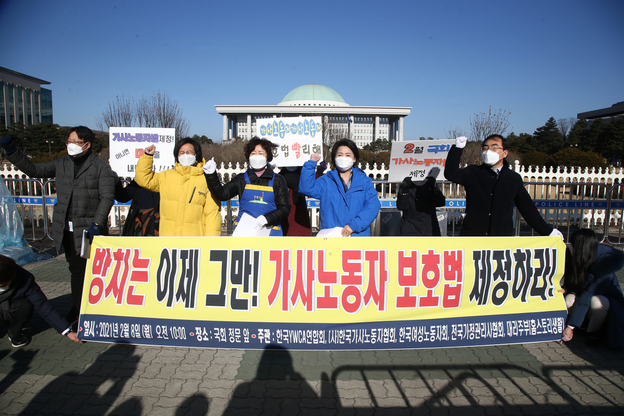 Rep. Kang Eun-mi of the progressive minior Justice Party (second from left) and Rep. Lee Soo-jin of the Democratic Party of Korea (center right) call for improved working conditions for domestic workers during a press conference held earlier this month in front of the National Assembly in Yeouido, western Seoul. (Yonhap)