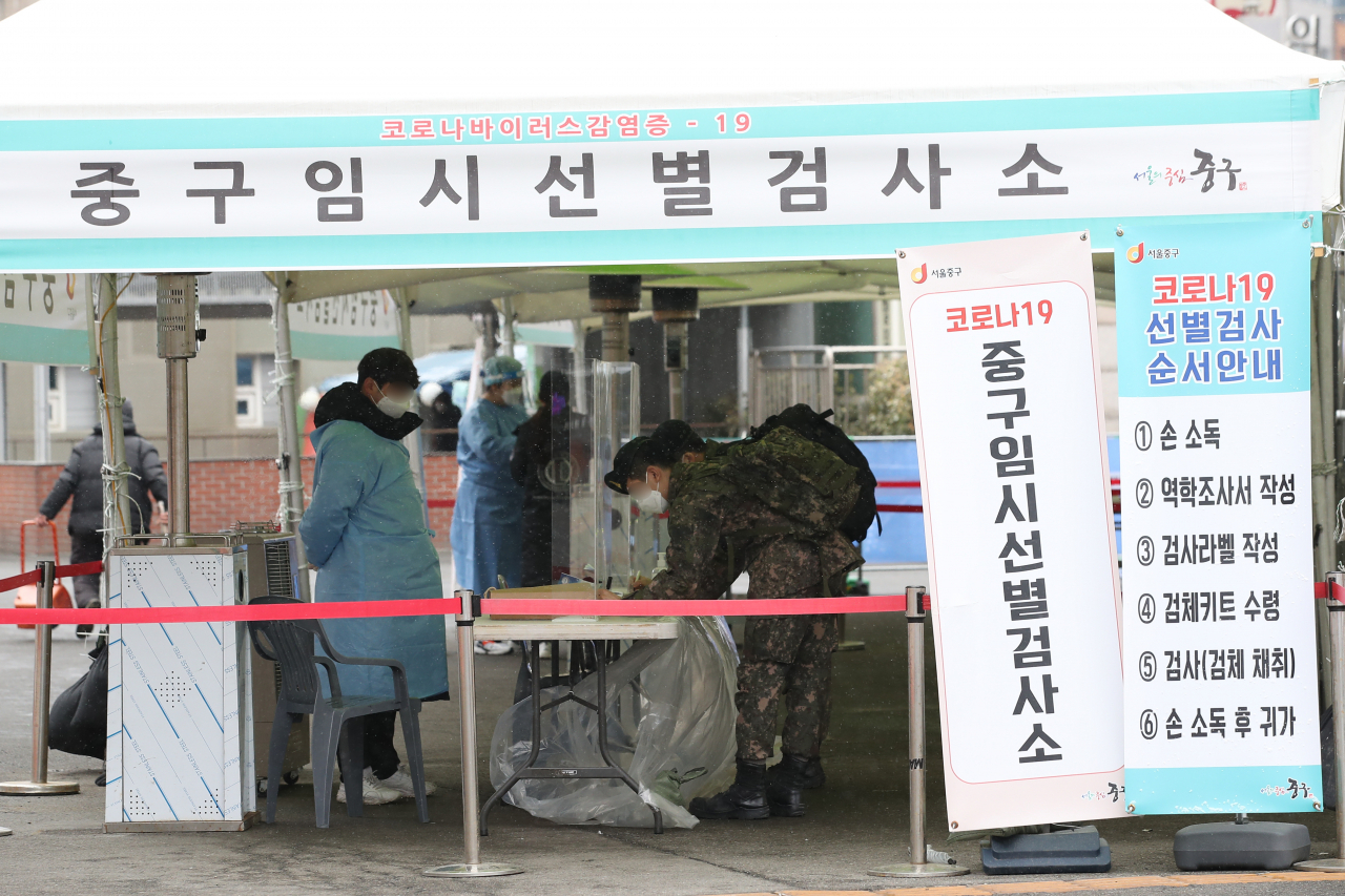 16일 오전 서울역에 마련된 코로나19 임시선별검사소를 찾은 장병들이 역학조사서를 작성하고 있다. [연합]