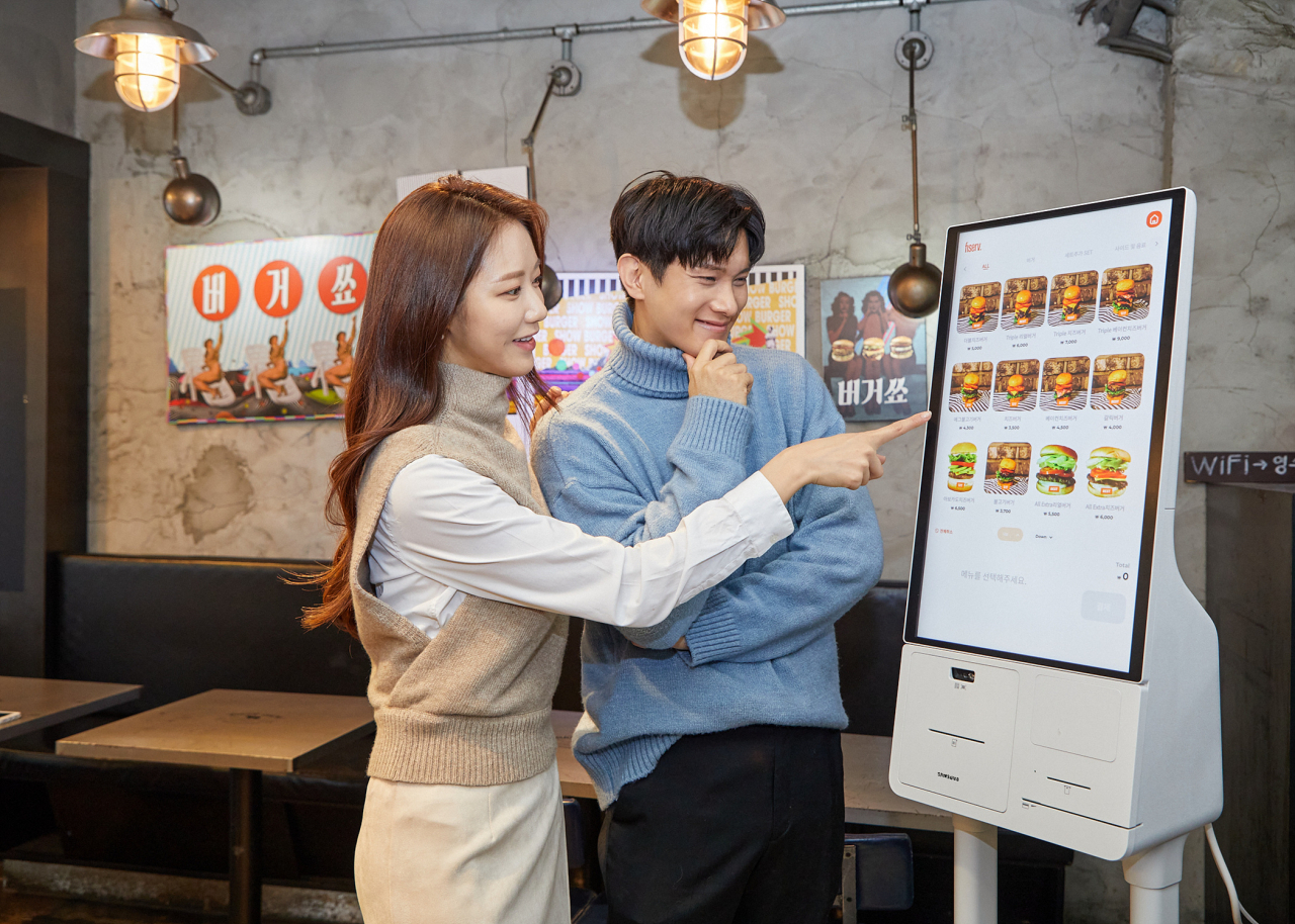 삼성전자 모델이 서울 영등포구에 위치한 카페 ‘보은하다’에 설치된 신제품 '삼성 키오스크'를 소개하고 있는 모습.[삼성전자 제공]