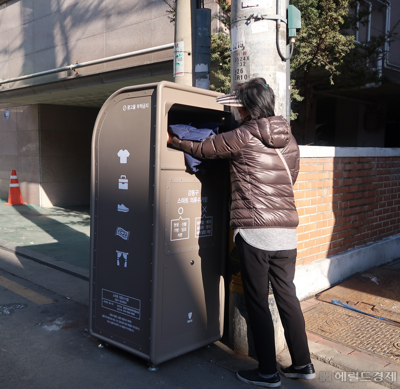 스마트 의류수거함에 한 주민이 의류를 버리고 있다. [강동구 제공]