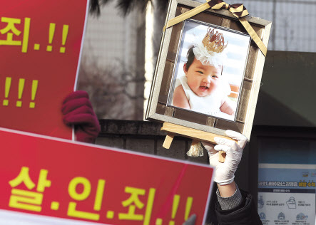 양부모에게 학대를 당해 숨진 16개월 영아 ‘정인이 사건’의 증인신문이 열린 17일 서울 양천구 서울남부지법 앞에서 시민들이 정인이의 영정 사진과 함께 양부모의 엄벌을 촉구하는 내용의 피켓을 들고 있다. [연합]