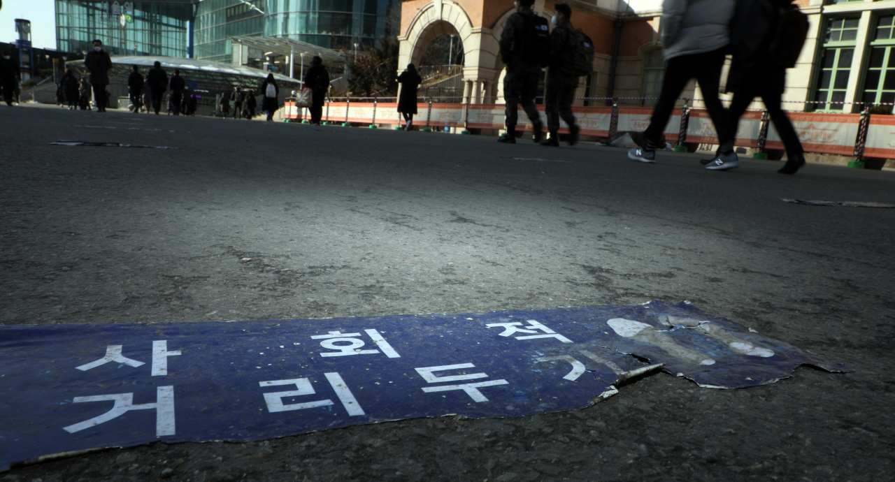 18일 서울 한 임시선별진료소 바닥에 붙은 거리두기 안내문이 닳아서 너덜너덜하다. 중앙방역대책본부는 이날 0시 기준 코로나19 신규 확진자는 621명이라고 밝혔다. 정부는 3월부터 시행하려는 집합금지를 최소화 거리두기 개편안을 코로나19 재확산 조짐으로 재검토하고 있다. [연합]