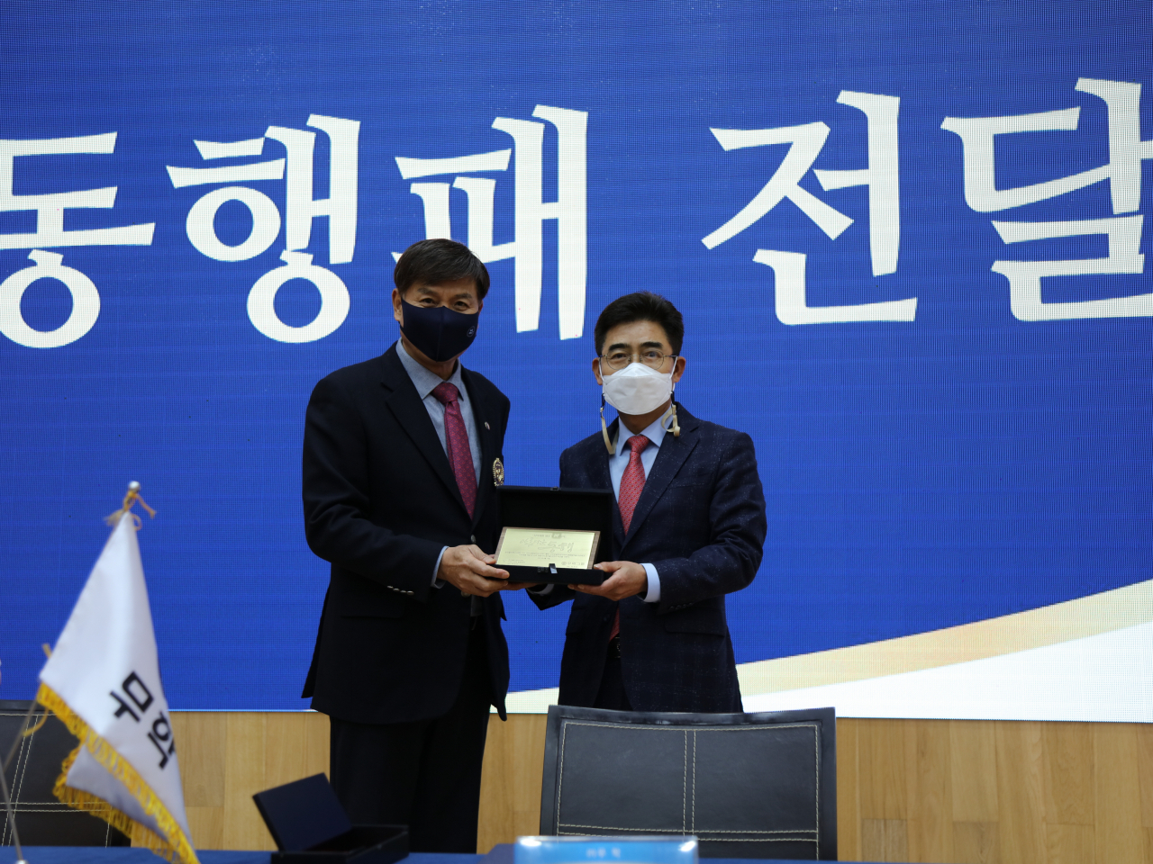 무학은 한국폴리텍Ⅶ대학 CEO 16대 총동문회와 17일 무학 본사 굿데이홀에서 업무협약을 체결하고 최재호 무학 회장(사진 왼쪽)이 박정우한국폴리텍Ⅶ대학 CEO 16대 총동문회장에게 아름다운 동행패를 전달했다. [무학 제공]