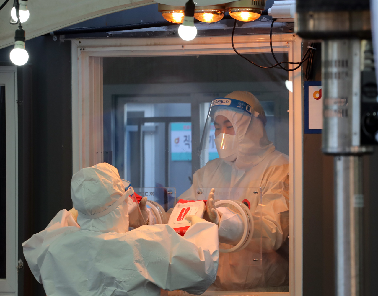 Health care workers are photographed at a testing center near Seoul station, central Seoul, Thursday morning. (Yonhap)