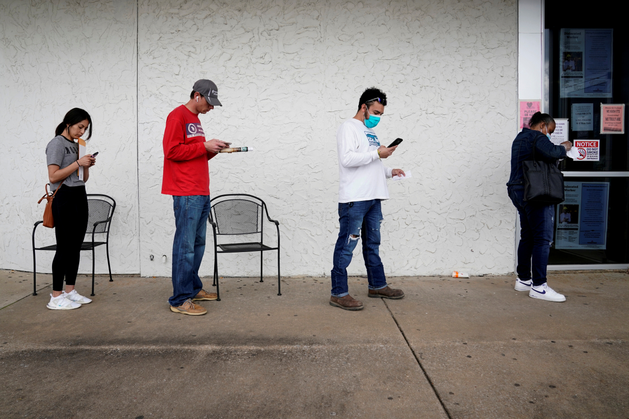 FILE PHOTO: People who lost their jobs wait in line to file for unemployment following an outbreak of the coronavirus disease (COVID-19), at an Arkansas Workforce Center in Fayetteville, Arkansas, U.S. April 6, 2020. REUTERS/Nick Oxford/File Photo[연합]
