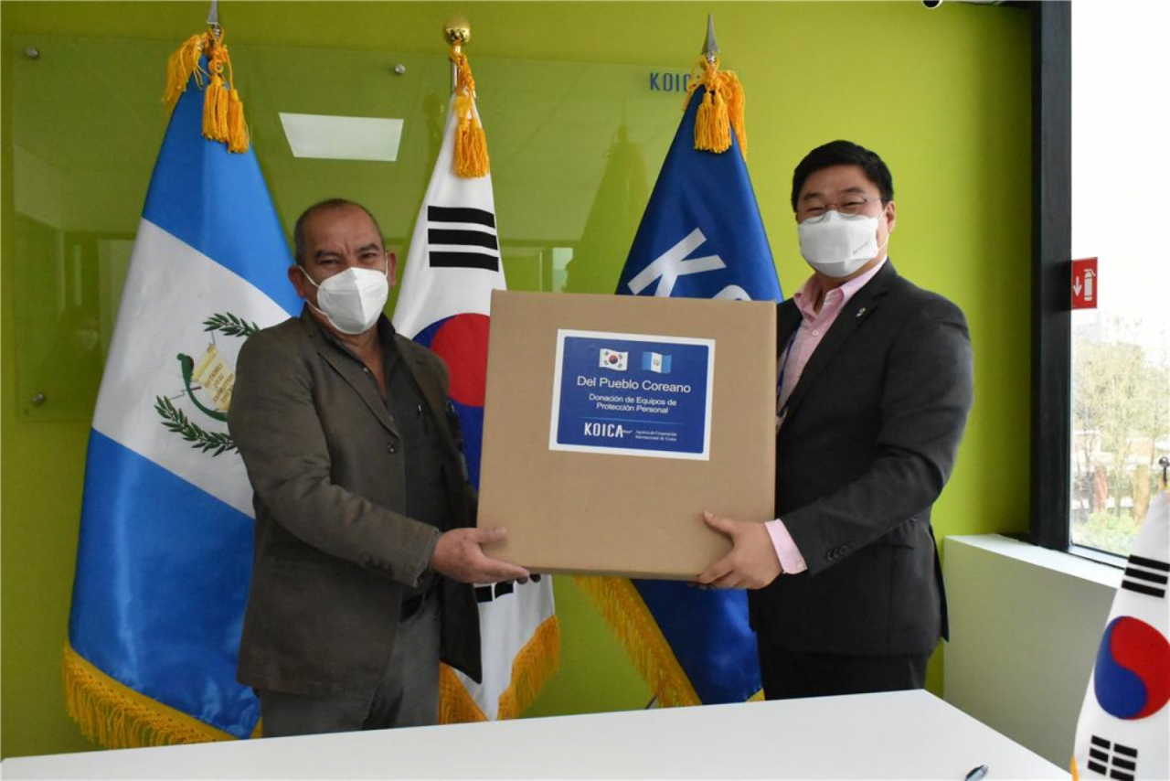 18일(현지 시각) 과테말라에서 코이카가 기지원한 과테말라 웨웨떼낭고주 모자보건 전문병원에 코로나19 극복을 위해 현지교민이 제작한 마스크와 방역복을 지원하는 기증식에서 강승헌 코이카 과테말라사무소장(오른쪽)이 웨웨떼낭고주 모자병원 병원장 오로솜 박사(왼쪽)에게 마스크가 든 박스를 전달하고 있다. [코이카 제공]