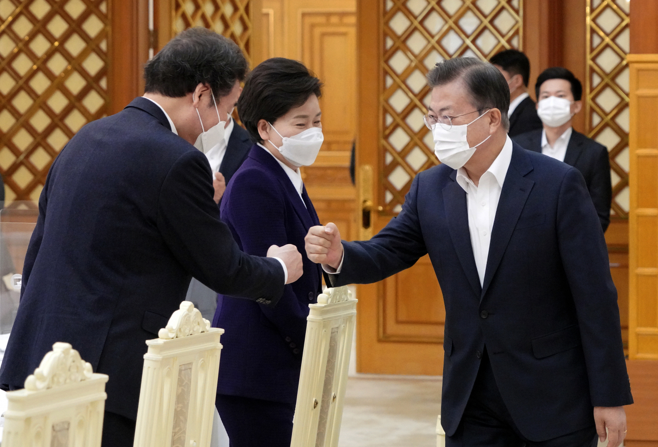 문재인 대통령이 19일 오전 청와대 본관에서 열린 더불어민주당 지도부 초청 간담회에 참석하며 이낙연 대표와 주먹인사를 하고 있다. [연합]