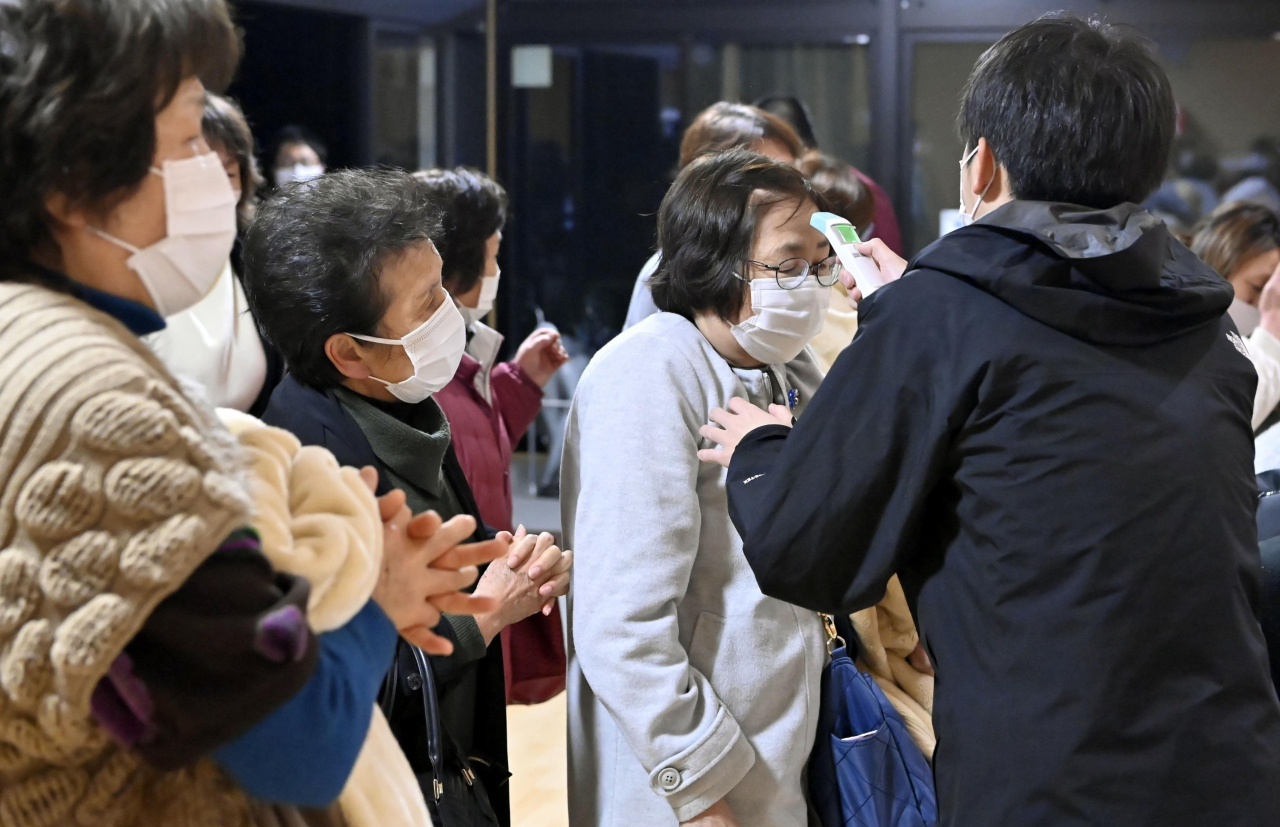 일본 후쿠시마(福島)현 앞바다에서 규모 7.3의 지진이 발생한 다음 날인 14일 후쿠시마현 소마(相馬)시의 피난소에 방문자가 체온 측정을 하고 있다. 연합뉴스