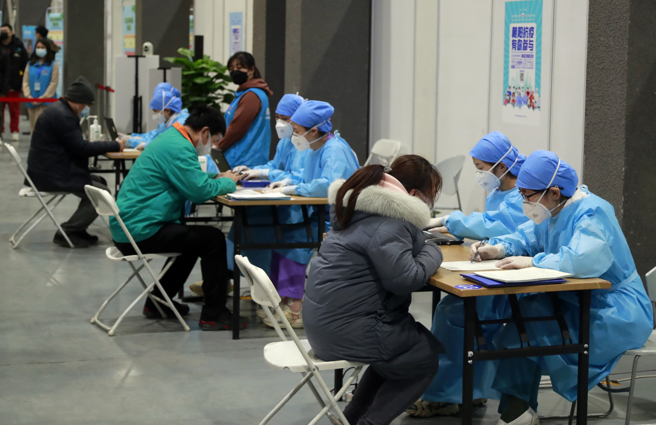 15일 중국 베이징 차오양구에서 신종 코로나바이러스 감염증(코로나19) 백신 접종 희망자가 의료진과 이야기를 나누고 있다. 2021. 1. 15. 연합뉴스