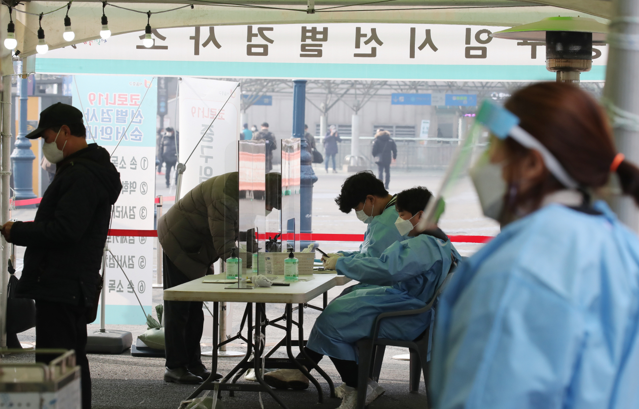 20일 오전 서울 중구 서울역 광장 신종 코로나바이러스 감염증(코로나19) 임시 선별 검사소에서 의료진이 시민들이 검사를 기다리고 있다. 중앙방역대책본부는 이날 0시 기준으로 코로나19 신규 확진자가 446명 늘어 누적 8만6천574명이라고 밝혔다. 전날보다 115명 줄었다. [연합]