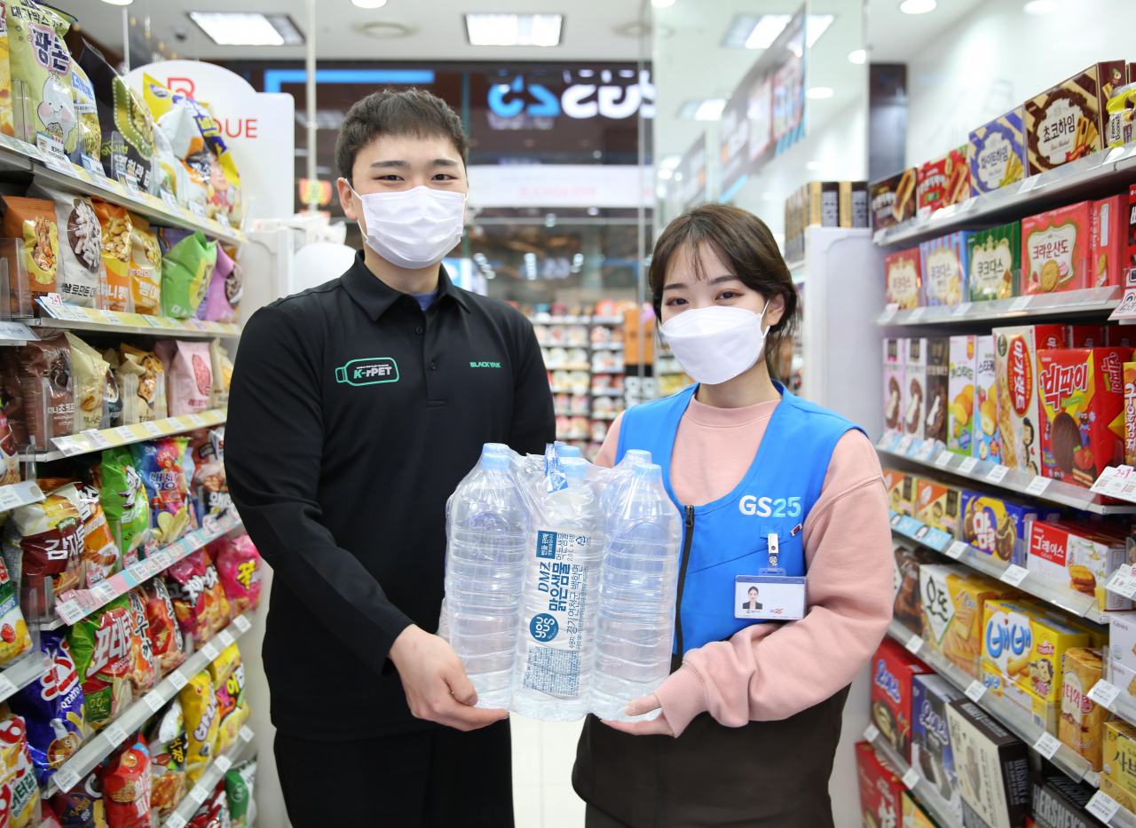 페트병으로 만든 블랙야크 티셔츠를 입은 모델들이 GS25의 무라벨 생수 페트병을 들고 있다.[GS25 제공]
