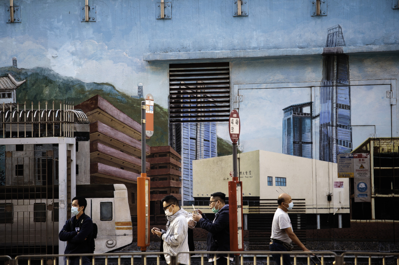 Passengers wait for bus against a mural of Hong Kong city. (Yonhap)