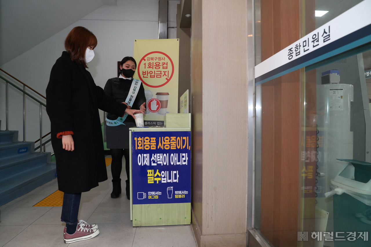 한 주민이 강북구 청사 입구에 설치된 1회용품 컵 회수함에 종이컵을 버리고 있다. [강북구 제공]