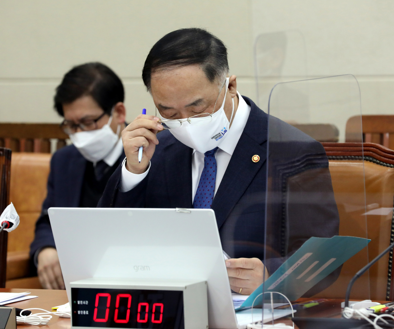 홍남기 부총리 겸 기획재정부 장관이 지난 19일 국회에서 열린 기획재정위원회 전체회의에서 자료를 살피고 있다. [연합]