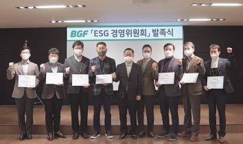이건준(오른쪽에서 다섯 번째), 홍정국(오른쪽에서 네 번째) 공동 위원장과 전담 리더들이 기념 촬영을 하고 있다. [BGF그룹 제공]
