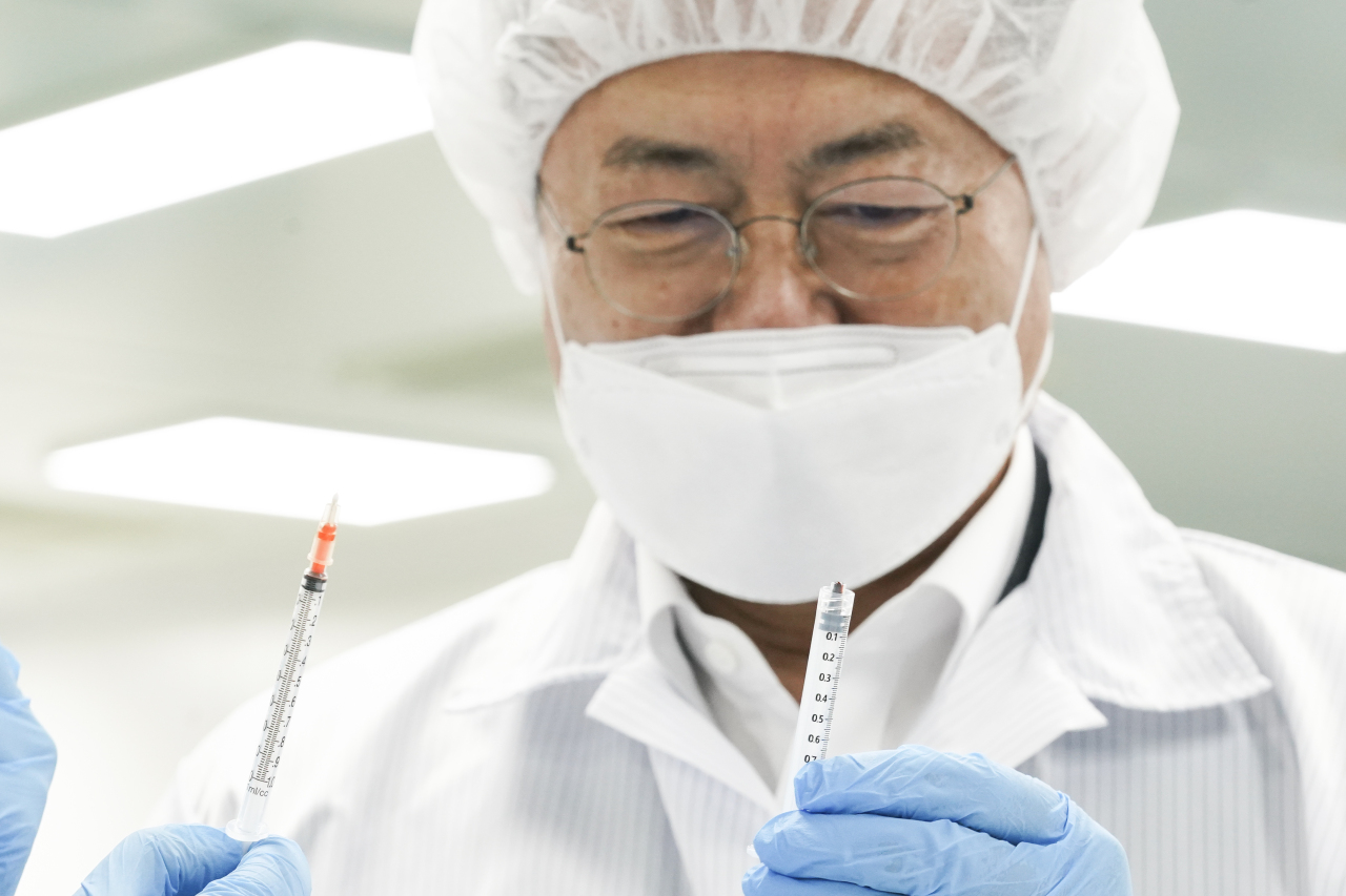 President Moon Jae-in looks at syringes at a plant in Gunsan, South Korea, on Feb. 18. (Yonhap)