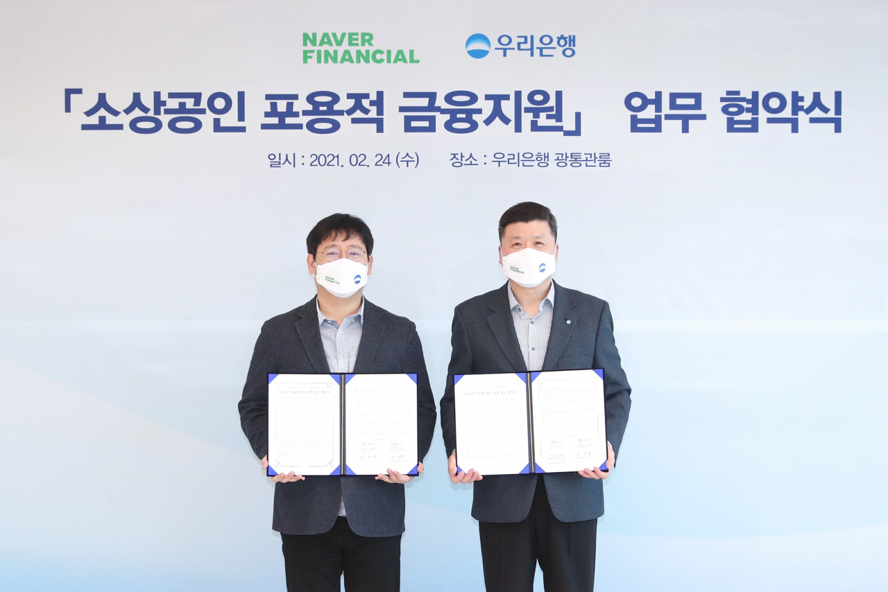 네이버파이낸셜과 우리은행은 24일 서울 중구 우리은행 본점에서 최인혁 네이버파이낸셜 대표 (왼쪽), 권광석 우리은행장 (오른쪽)을 비롯한 양사 주요 관계자들이 참석한 가운데 ‘소상공인 포용적 금융지원’을 위한 업무 협약을 맺었다. [네이버파이낸셜 제공]