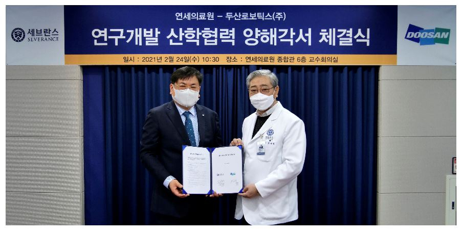 두산로보틱스 최동휘 대표(왼쪽)와 연세의료원 윤동섭 원장이 '의료로봇 연구개발 산학협력' 업무협약식을 마치고 기념사진을 촬영하고 있다.[두산 제공]