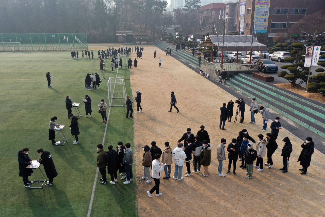 지난해 12월23일 오전 광주 서구 화정동 광덕고등학교 운동장에서 3학년 학생들이 대학수학능력시험 성적표를 받고 있는 모습. 신종 코로나 바이러스 감염증(코로나19) 확산을 예방하고자 야외에서 수능 성적표를 배부했다. [연합]