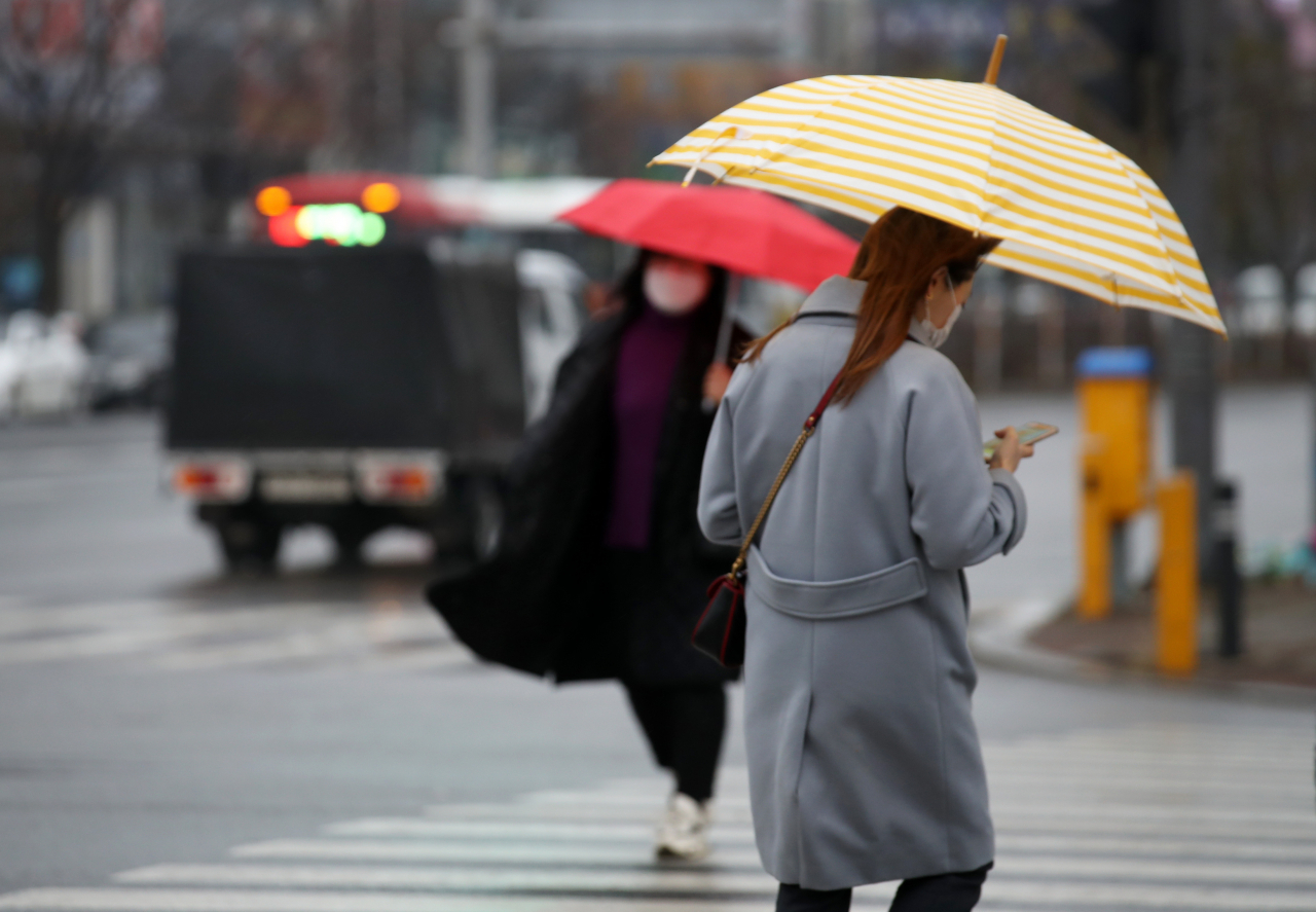 눈이 녹아 비가 된다는 절기상 우수(雨水)를 사흘 앞둔 지난 15일 오전 광주 서구 상무중앙로에서 시민들이 우산을 쓰고 거리를 걷고 있다. [연합]