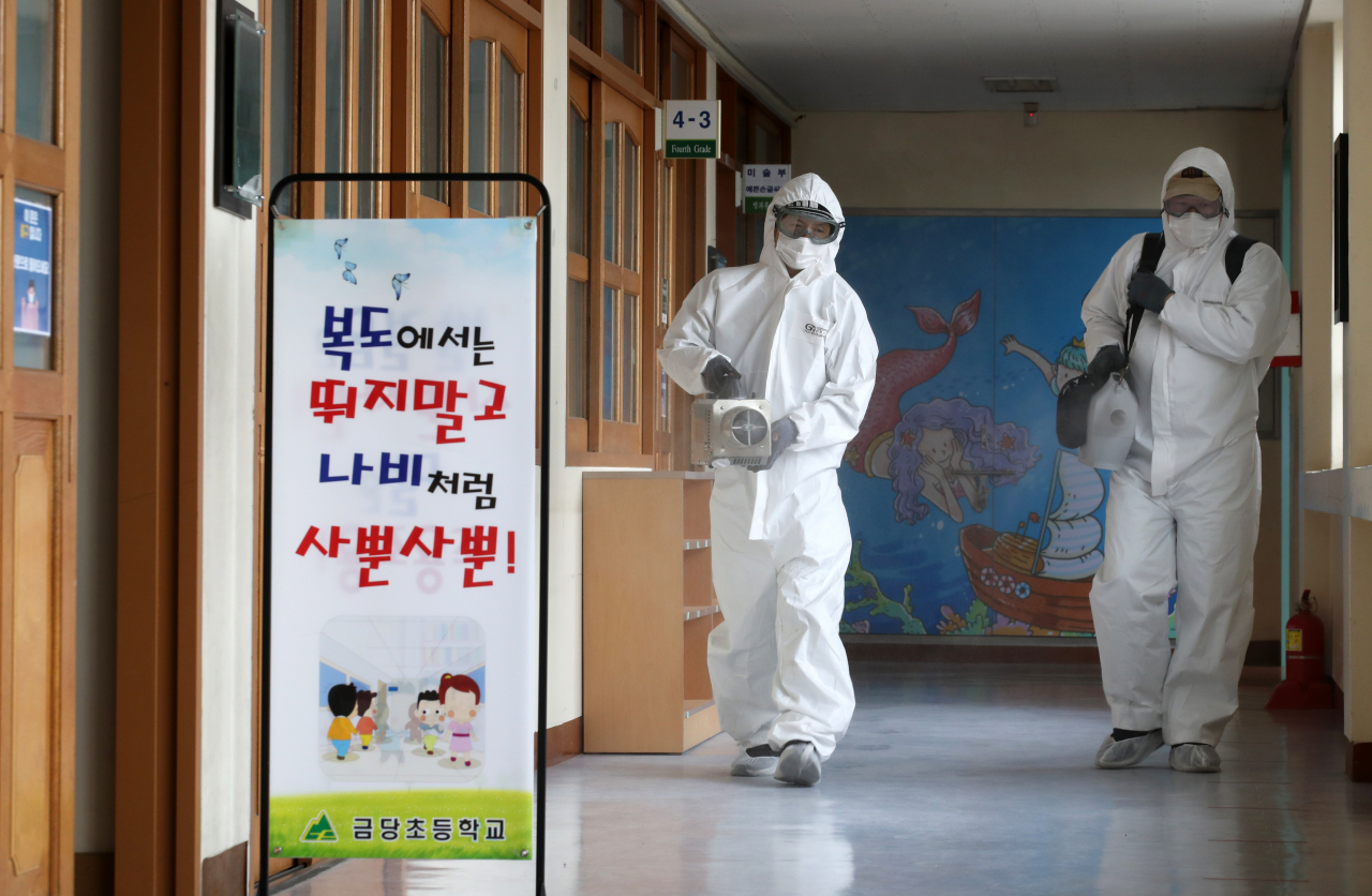 2021학년도 새 학기 개학을 엿새 앞둔 24일 광주 서구 금당초등학교에서 방역요원이 신종 코로나바이러스 감염증(코로나19) 예방을 위해 방역하고 있다. [연합]