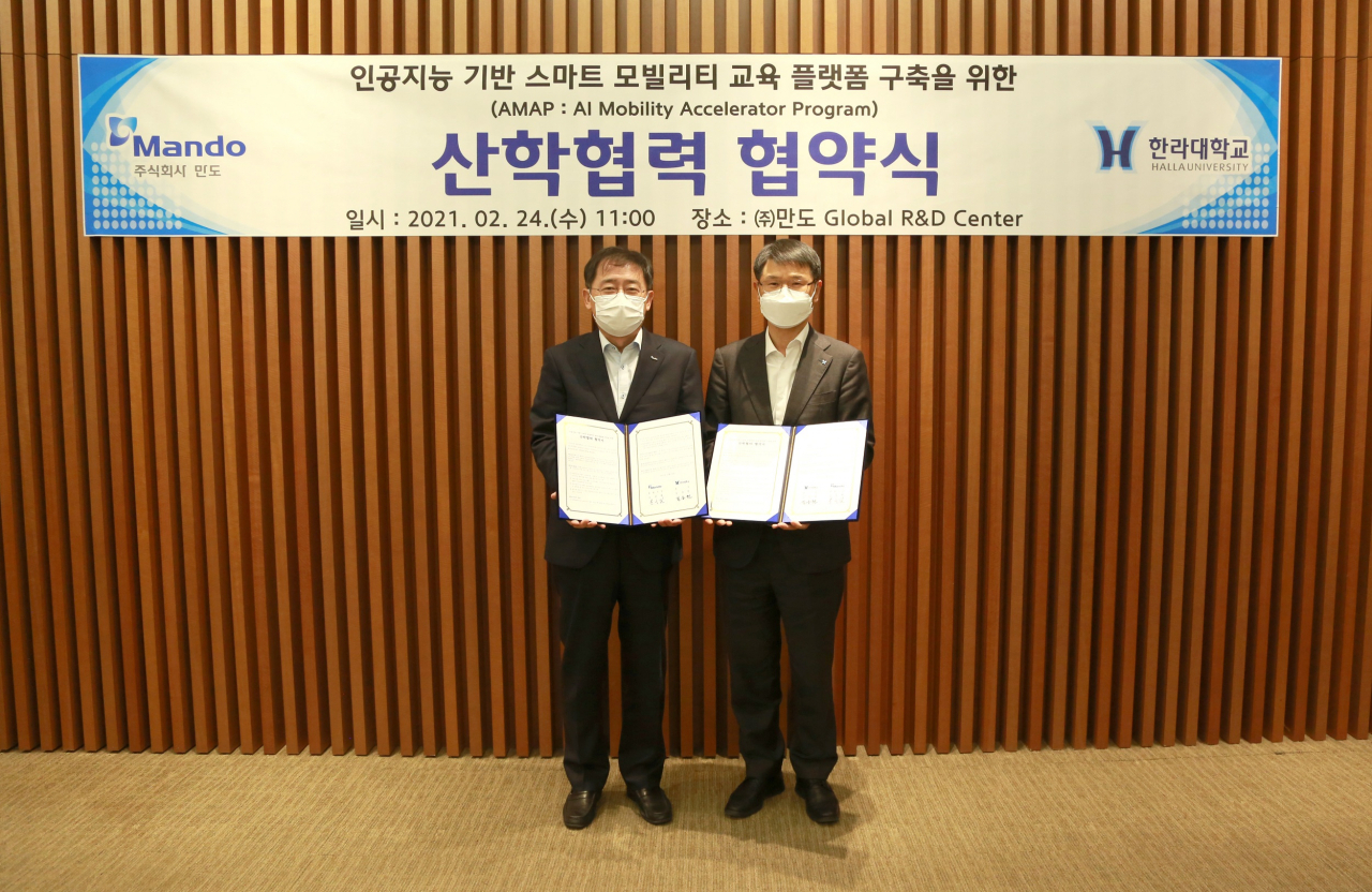 만도 조성현 총괄사장(왼쪽)과 한라대학교 김응권 총장이 판교 만도 R&D센터에서 MOU체결 후 기념촬영을 하고 있다. [만도 제공]