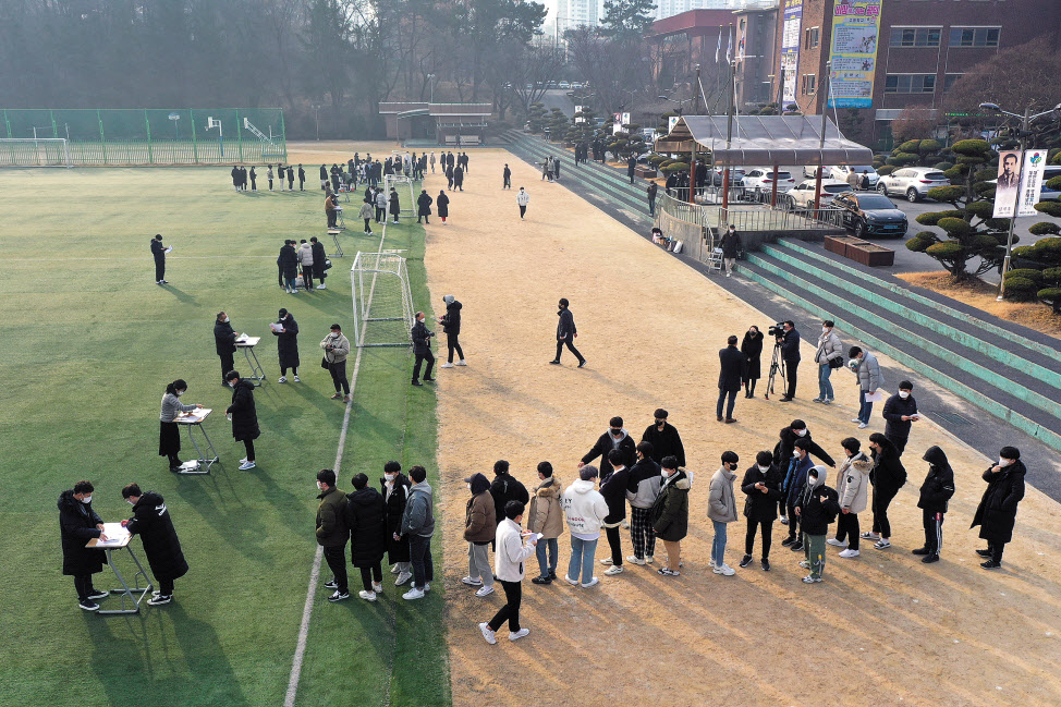 지난해 12월 23일 오전 광주 서구 화정동 광덕고등학교 운동장에서 3학년 학생들이 대학수학능력시험 성적표를 받고 있다. 신종 코로나바이러스 감염증(코로나19) 확산을 예방하고자 야외에서 수능 성적표를 배부했다. [연합]