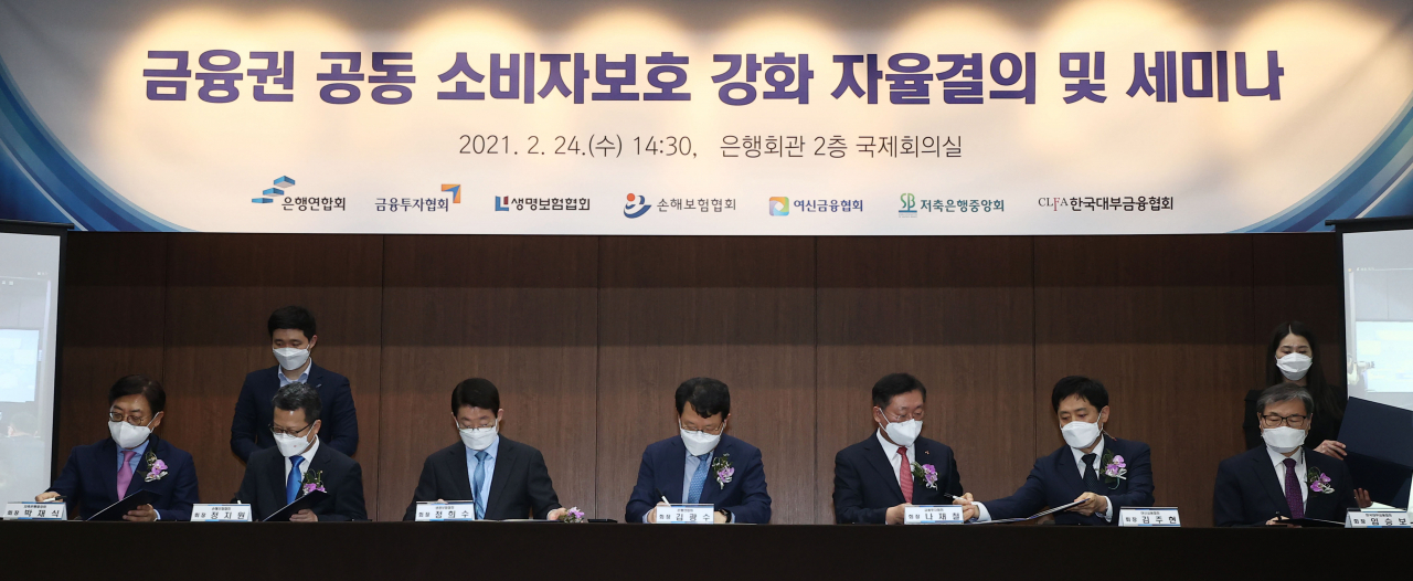 24일 오후 서울 중구 은행회관에서 열린 소비자보호 강화를 위한 금융권 공동 자율결의 및 세미나에서 김광수 은행연합회장(가운데) 등 참석자들이 결의문에 서명하고 있다. [연합]