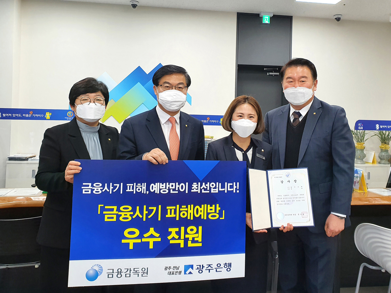 광주은행 이광호 부행장(왼쪽 두번째)이 금융감독원을 대신해 송정지점 서윤정 대리에게 감사장을 전달하고 있다.[광주은행 제공]