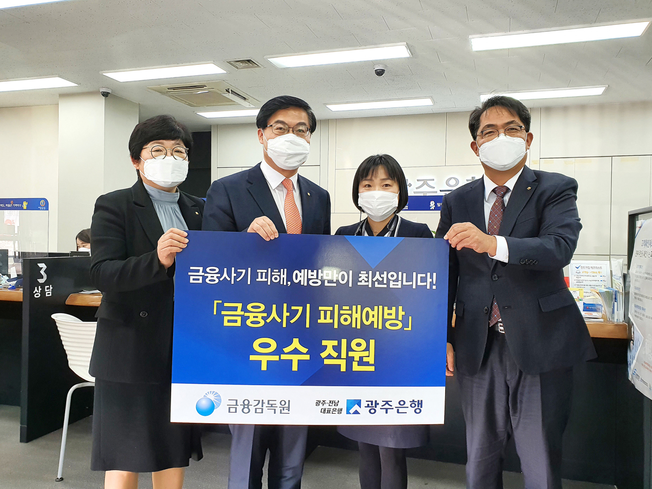 광주은행 이광호 부행장(왼쪽 두번째)이 금융감독원을 대신해 신안동지점 신경자 대리에게 감사장을 전달하고 있다.[광주은행 제공]