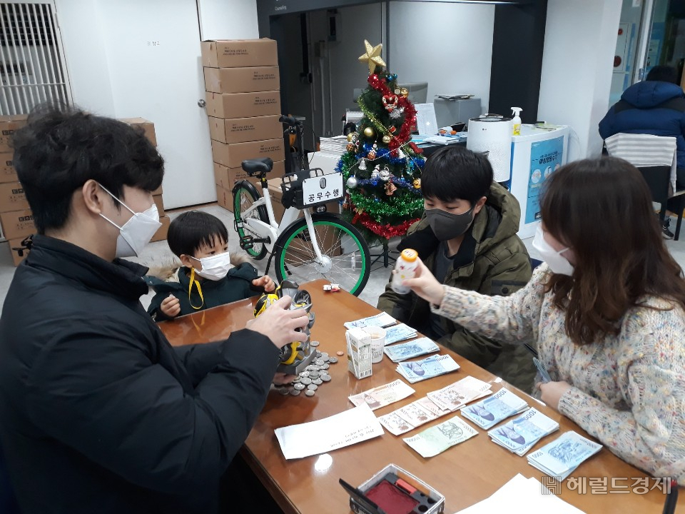 송파구 거여동에 거주하는 어린이들이 저금통에 모든 돈을 송파구에 기탁하고 있다. [송파구 제공]
