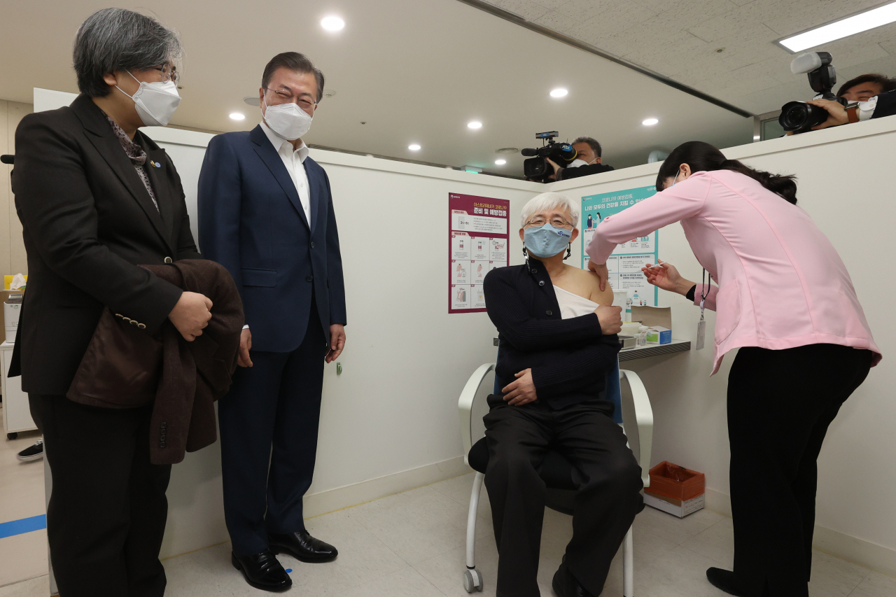 문재인 대통령과 정은경 질병관리청장이 지난달 26일 서울 마포구보건소를 방문, 재활시설 종사자인 김윤태 의사(푸르메 넥슨어린이 재활병원)가 아스트라제네카(AZ) 백신을 접종받는 모습을 지켜보고 있다. [연합]