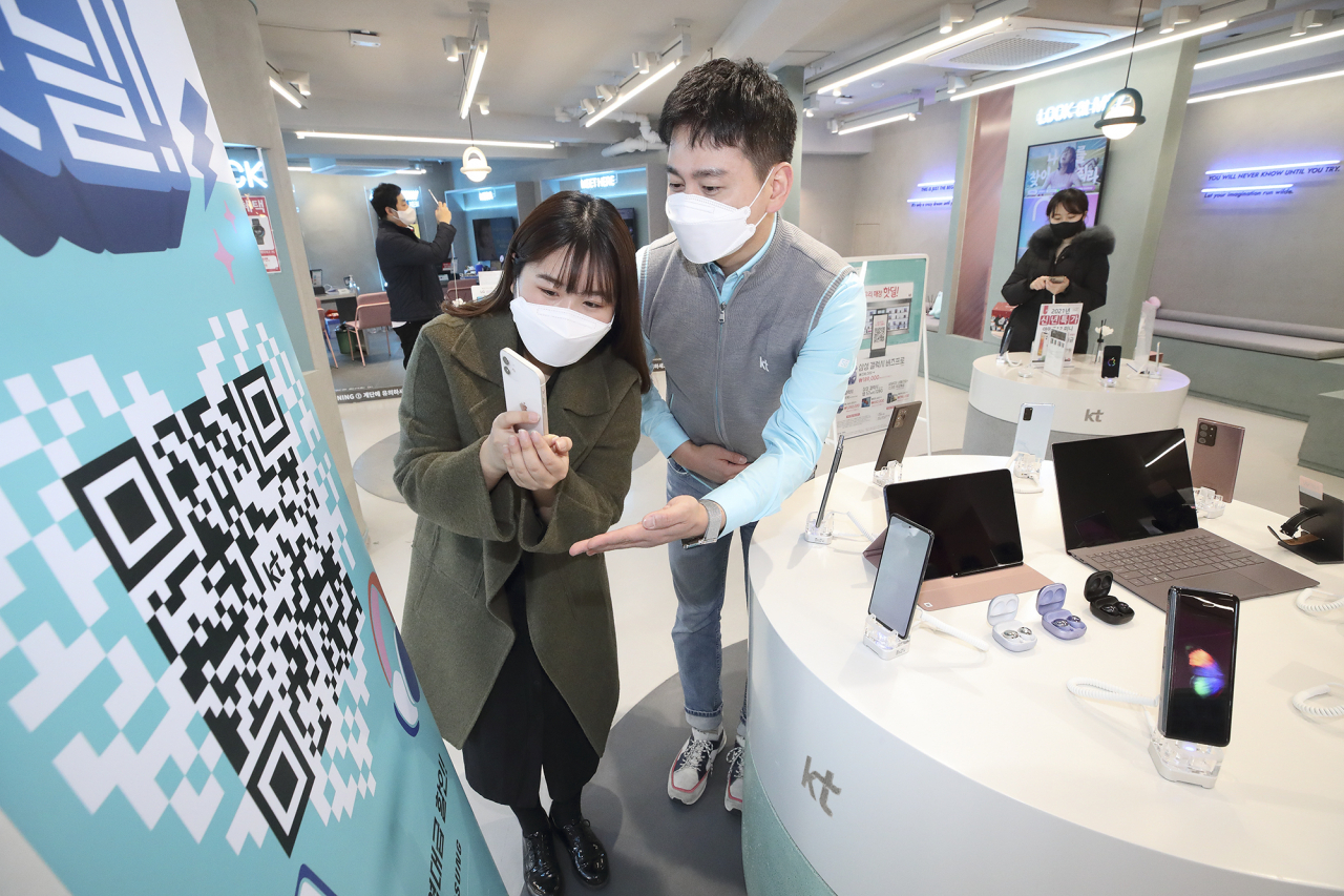 KT 매장을 방문한 고객이 ‘우리매장핫딜’ QR 코드를 촬영하고 있다.[KT 제공]