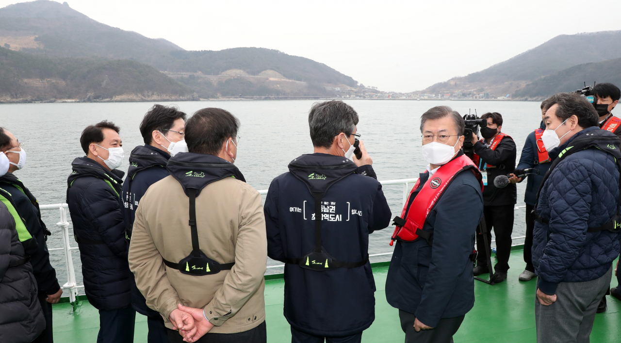 문재인 대통령이 25일 부산에서 열린 '동남권 메가시티 구축 전략 보고'에 참석, 가덕도 공항 예정지를 어업지도선을 타고 시찰하며 이병진 부산시장 권한대행으로부터 관련 보고를 청취하고 있다. [연합]