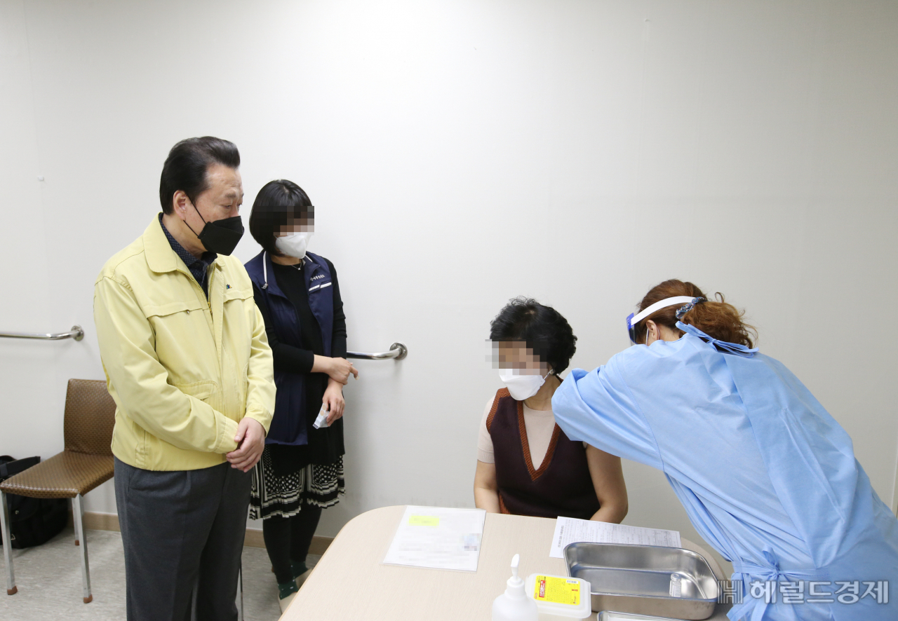 26일 오전 강서구 방화동 한 요양시설에서 노현송 구청장(노란색 상의)이 첫 백신 접종이 이뤄지는 현장을 지켜보고 있다. [강서구 제공]