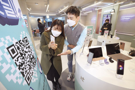 KT 매장을 방문한 고객이 ‘우리매장핫딜’QR 코드를 촬영하고 있다. [KT 제공]