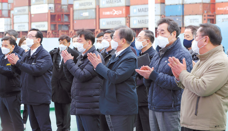 문재인 대통령이 25일 부산에서 열린 ‘동남권 메가시티 구축 전략 보고’에 더불어민주당 이낙연 대표, 김태년 원내대표 등과 참석, 부산신항 한나라호에서 김경수 경상남도지사로부터 동북아 스마트 물류 플랫폼 구축 등 경제공동체 방안을 포함한 ‘동남권 메가시티 비전’ 보고를 받고 박수치고 있다. [연합]