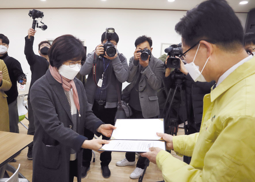 충남 지역 신종 코로나바이러스 감염증(코로나19) 첫 백신 접종자인 김미숙(64)씨가 26일 오전 홍성보건소에서 백신을 맞고 양승조 지사로부터 확인서를 받고 있다. [연합]