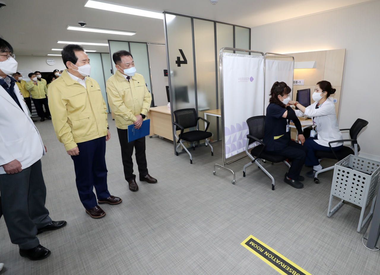 정세균 국무총리가 27일 오전 서울 중구 국립중앙의료원 중앙예방접종센터에서 의료원 관계자가 화이자 백신을 접종받는 모습을 참관하고 있다. ［연합］