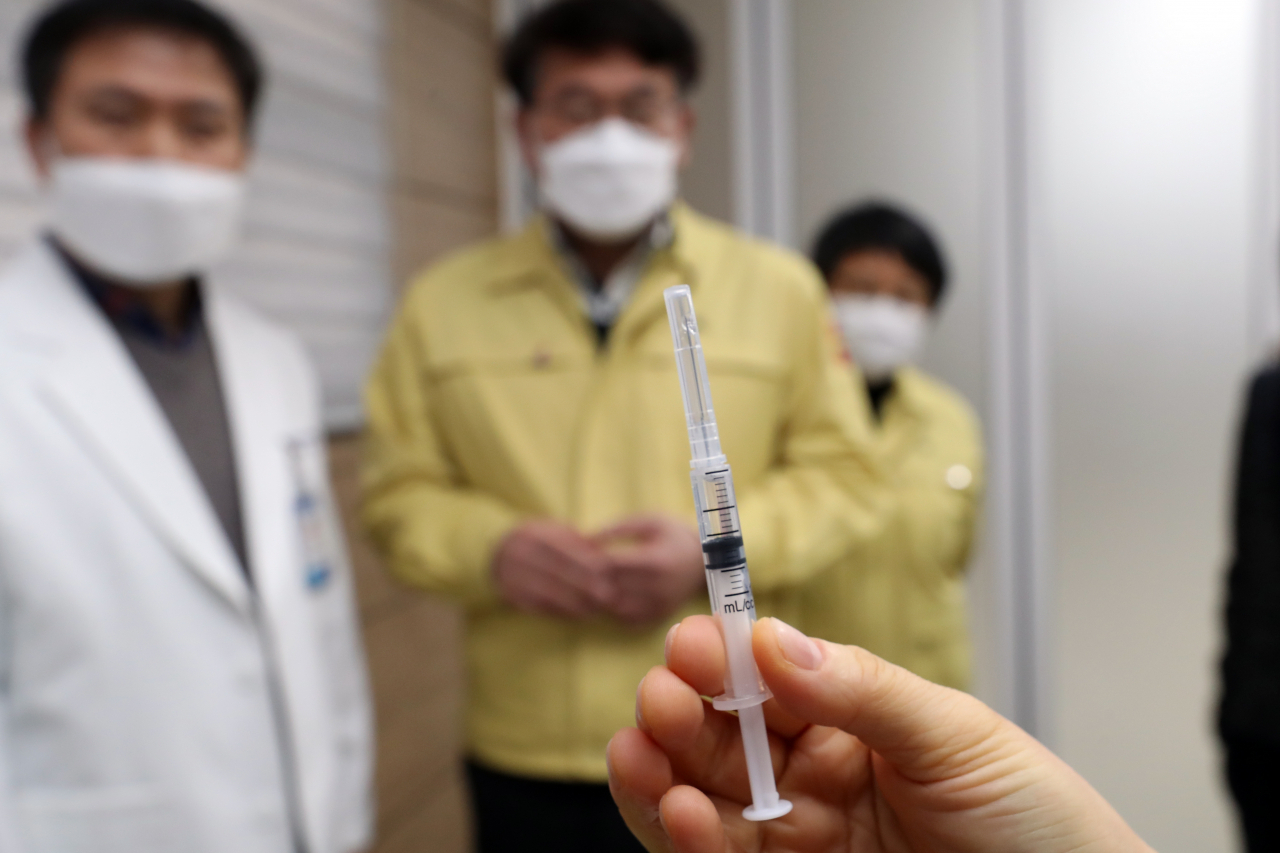 지난 27일 오전 광주 서구 다사랑병원에서 의료진이 아스트라제네카(AZ) 백신이 담긴 최소 잔여형 주사기를 손에 들고 있다. 이 병원 신재정 원장(뒷줄 왼쪽부터), 광주시 김종효 행정부시장과 박향 복지건강국장이 주사기를 살펴보고 있다. [연합]