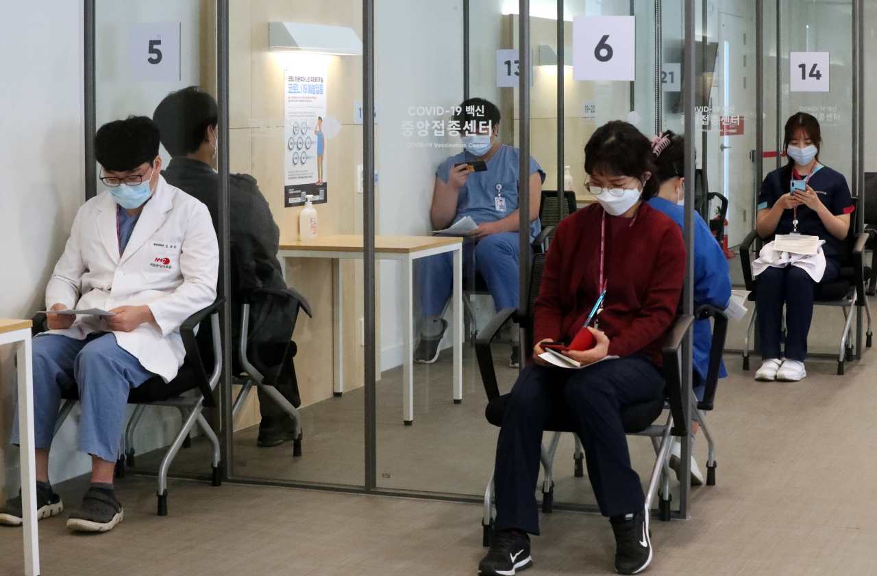 27일 오전 서울 중구 국립중앙의료원 중앙예방접종센터에서 코로나19 화이자 백신 1차 접종이 시작되면서 주사를 맞은 의료 종사자들이 관찰실에서 대기하고 있다. [연합]