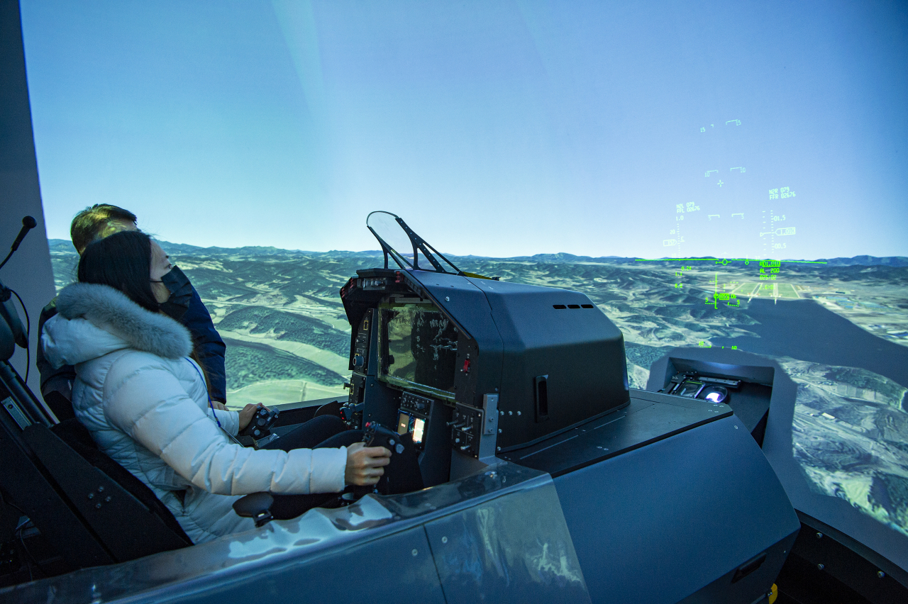 본지 문재연 기자가 한국형 전투기(KF-X) HQS(조종성평가시뮬레이터)에 앉아 기기를 작동하고 있다. [방위사업청 제공]